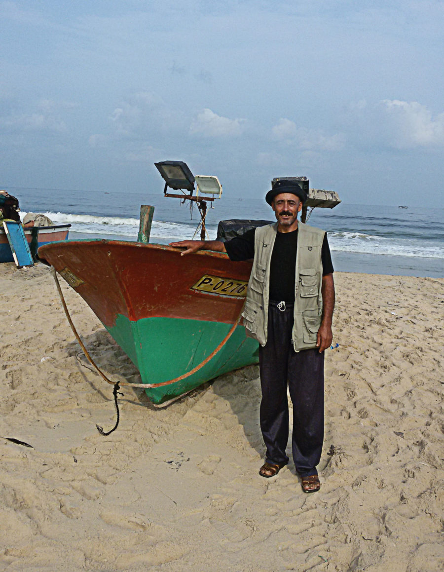 Adel Ferwana stands near his fishing boat in Gaza.