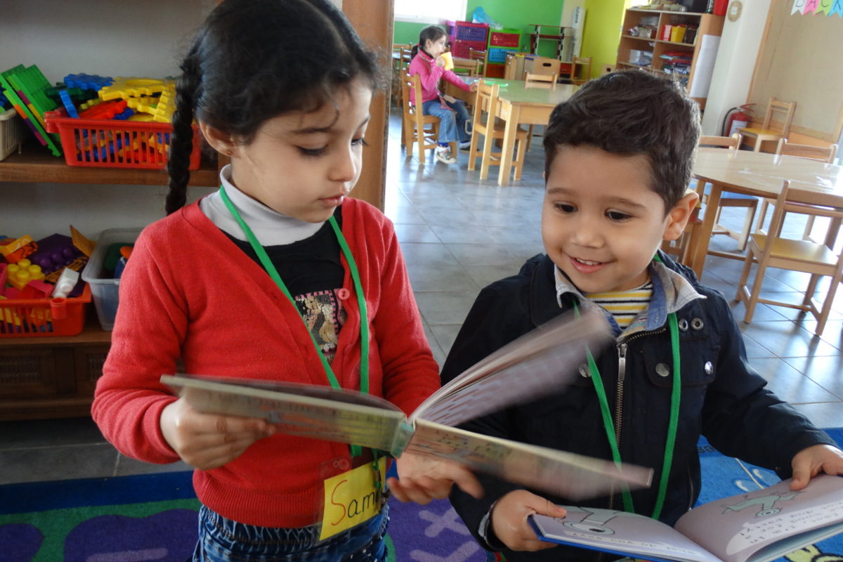 Young children read at the mobile library in Lebanon.