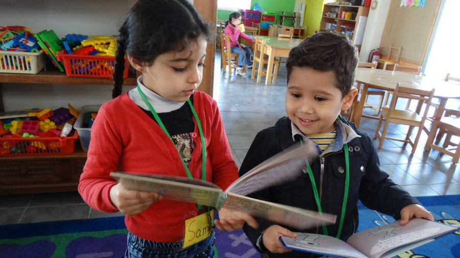 Young children read at the mobile library in Lebanon.