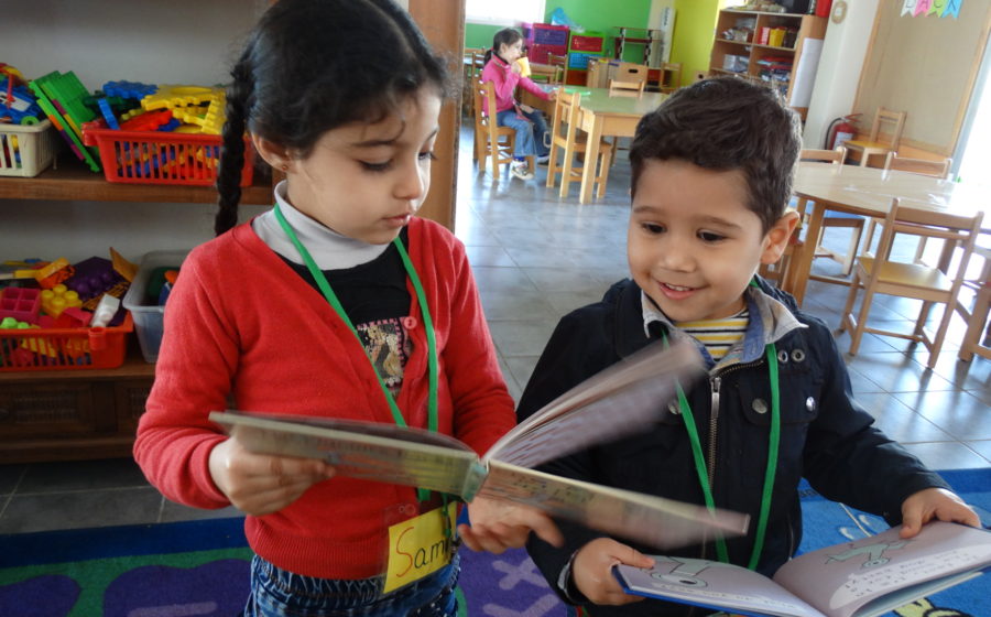 Young children read at the mobile library in Lebanon.