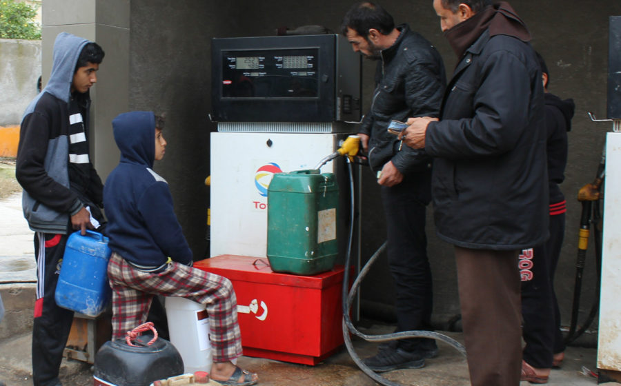 Children wait in line to fill up their container of kerosene in Jordan.
