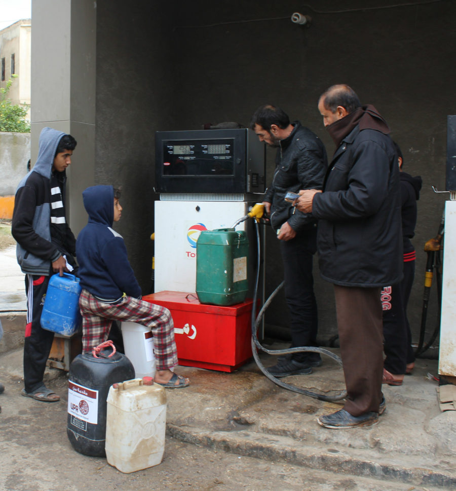 Children wait in line to fill up their container of kerosene in Jordan.