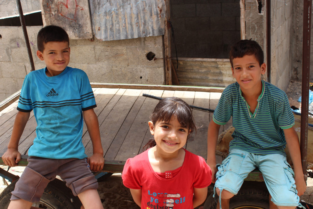 Gaza children sit outside their dwelling in Gaza.