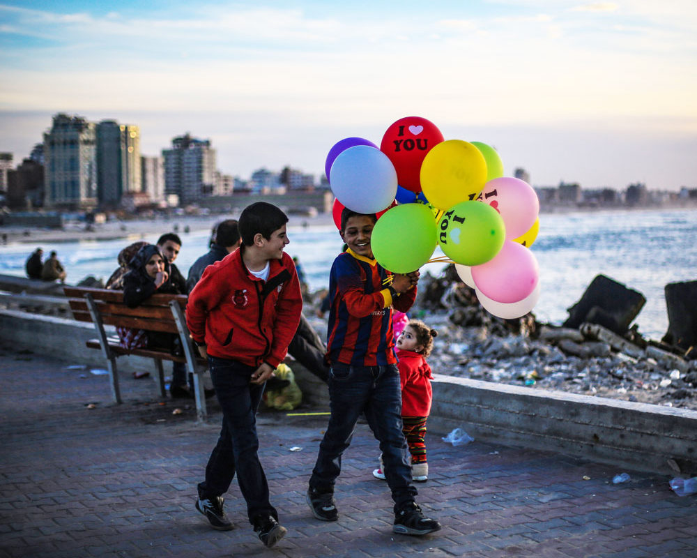 Kids walk with balloons in Gaza.