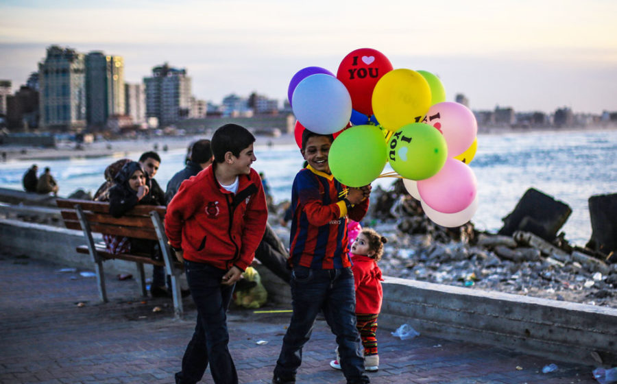 Kids walk with balloons in Gaza.